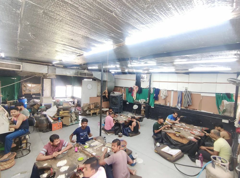 Artisans hand-setting stones at the bench in the Jaipur workshop